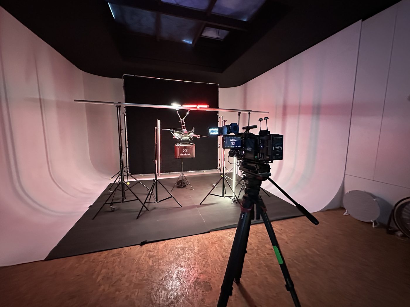 De cyclorama in roze licht met een camera op statief